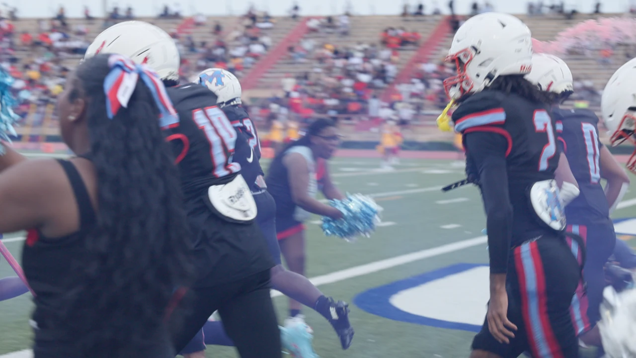 Madison players running out through blue smoke onto the field.